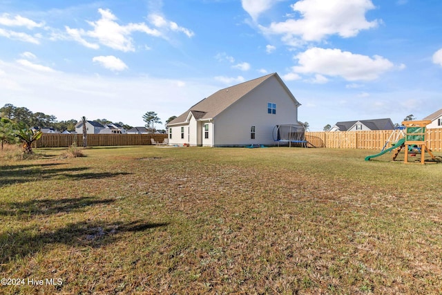 view of yard with a playground and a trampoline