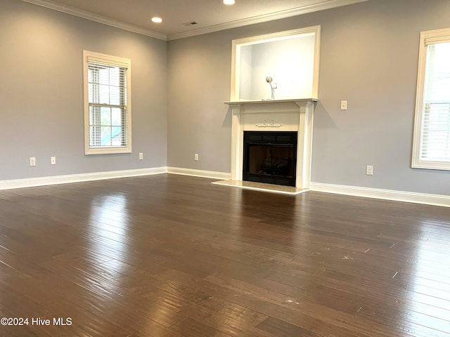 unfurnished living room with dark hardwood / wood-style flooring, a healthy amount of sunlight, and ornamental molding