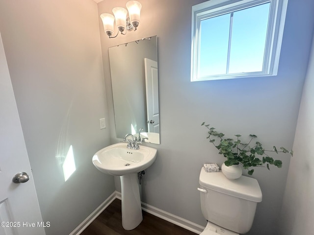 half bath with wood finished floors, toilet, and baseboards