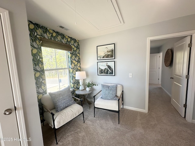 living area featuring attic access, visible vents, carpet floors, and baseboards