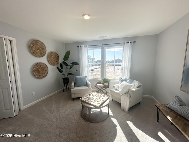 living area featuring baseboards, visible vents, and carpet flooring