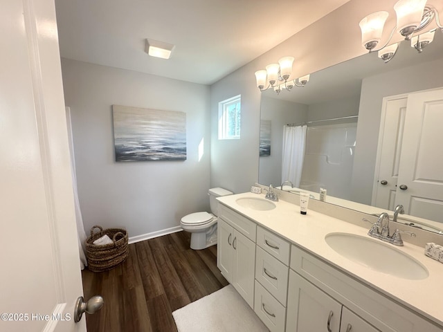 full bathroom with toilet, a chandelier, a sink, and wood finished floors