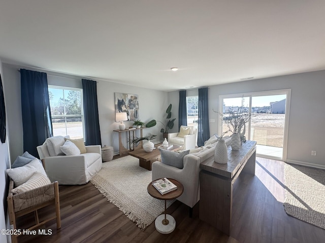 living area featuring a healthy amount of sunlight, dark wood finished floors, and baseboards