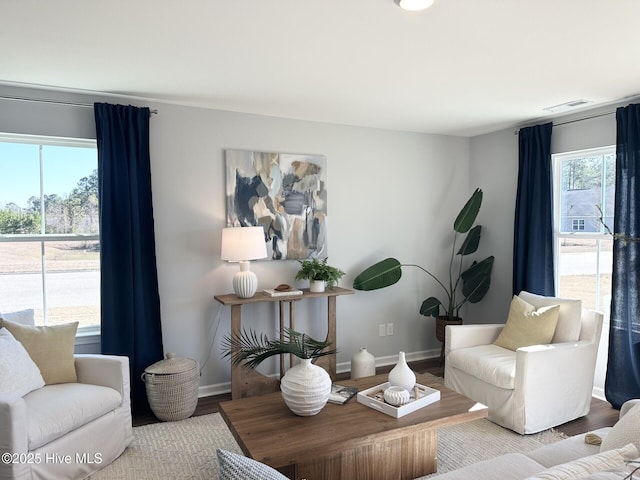 living room featuring light wood-style floors, baseboards, and visible vents