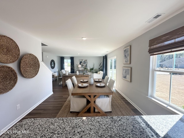 dining area with baseboards, visible vents, and dark wood-style flooring