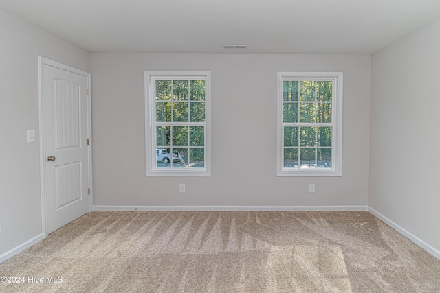 unfurnished room featuring light carpet