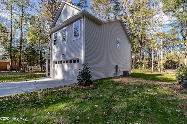 view of property exterior with a yard, a garage, and central air condition unit