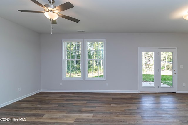 spare room with plenty of natural light, dark wood-type flooring, and ceiling fan