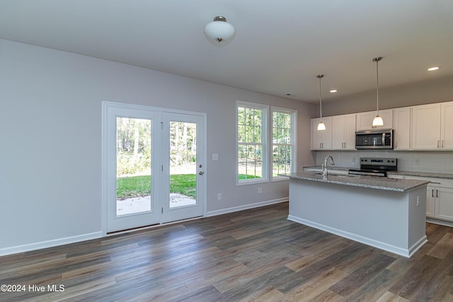 kitchen with white cabinetry, decorative light fixtures, a center island with sink, and appliances with stainless steel finishes