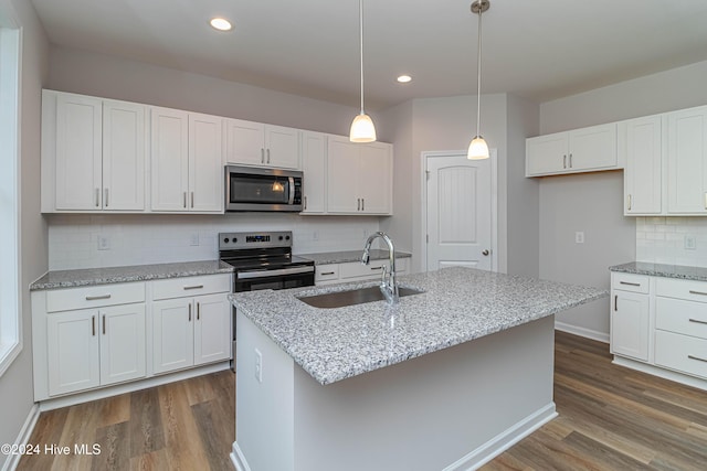 kitchen featuring white cabinetry, appliances with stainless steel finishes, a kitchen island with sink, and sink