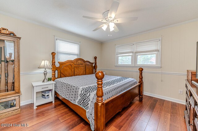 bedroom with hardwood / wood-style flooring, ceiling fan, and crown molding