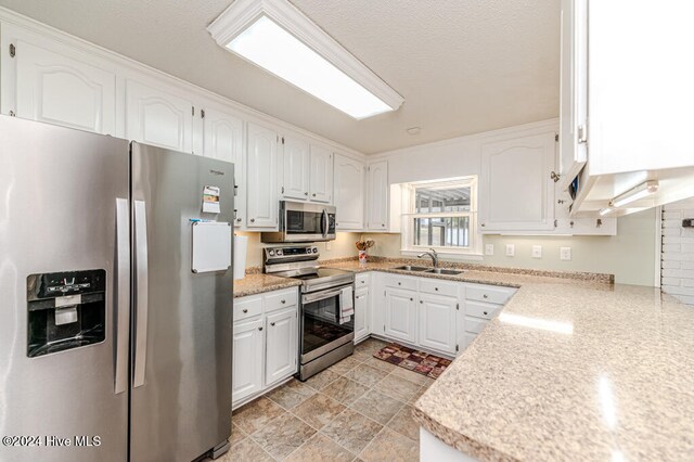 kitchen featuring stainless steel appliances, white cabinetry, and sink