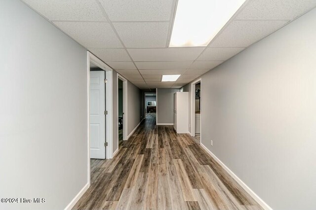 hallway featuring hardwood / wood-style floors and a drop ceiling