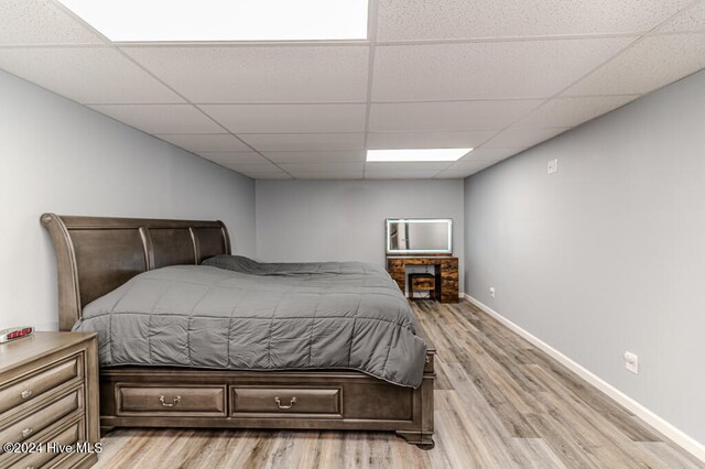 bedroom featuring a drop ceiling and light hardwood / wood-style floors