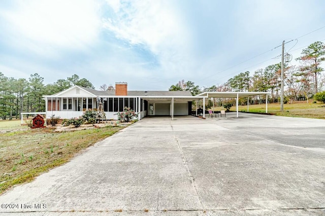 single story home with a sunroom, a carport, and a front lawn