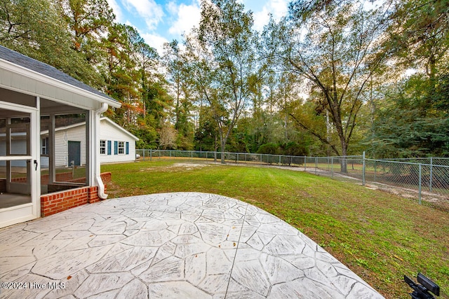 view of yard with a sunroom and a patio