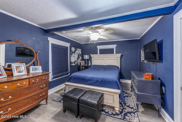 bedroom featuring ceiling fan, crown molding, light hardwood / wood-style floors, and a textured ceiling