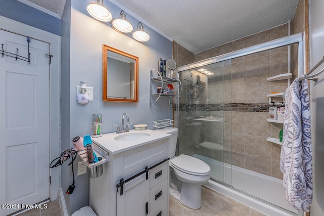 bathroom with tile patterned floors, vanity, a shower with door, and a textured ceiling