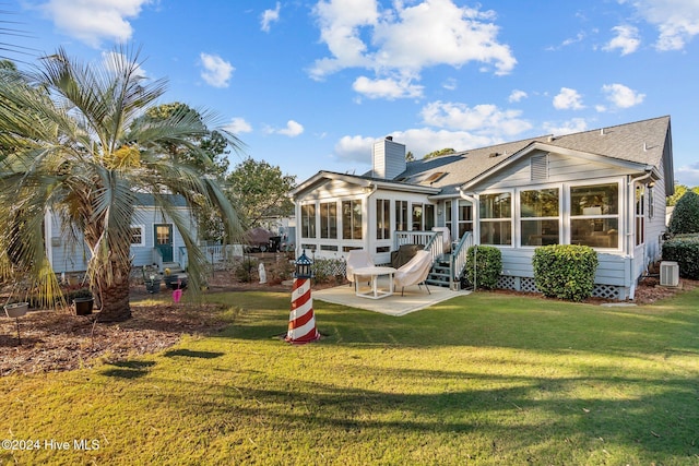 back of property with a yard, a sunroom, a patio, and central air condition unit