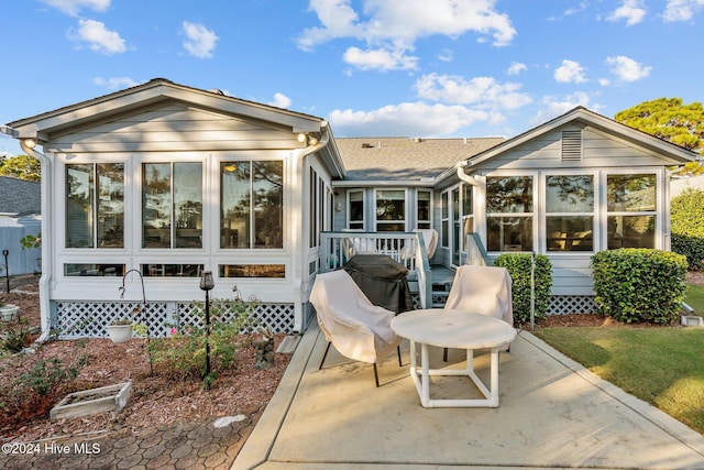 rear view of house with a patio area and a sunroom