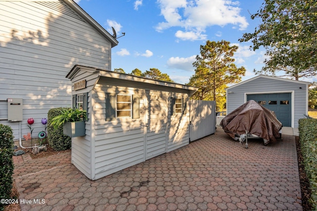 view of side of home featuring an outbuilding, a garage, and a patio area