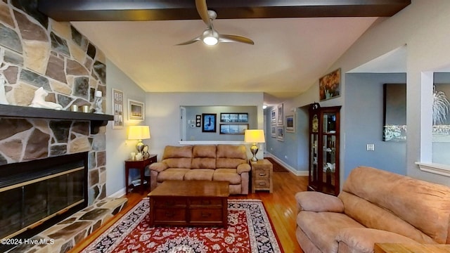 living room with vaulted ceiling with beams, wood-type flooring, a fireplace, and ceiling fan