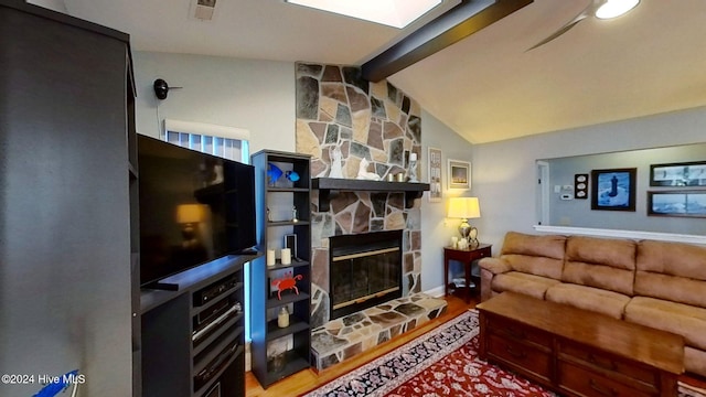 living room featuring hardwood / wood-style flooring, a fireplace, and lofted ceiling with skylight