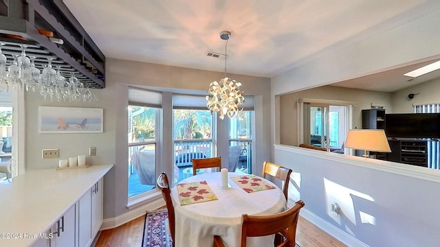 dining space featuring a chandelier, light hardwood / wood-style floors, and a wealth of natural light