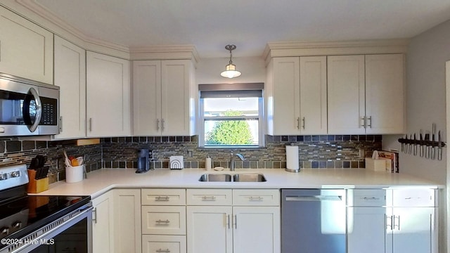 kitchen with pendant lighting, stainless steel appliances, sink, and white cabinets