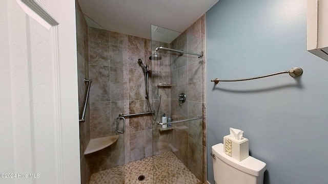 bathroom featuring a shower with door and toilet