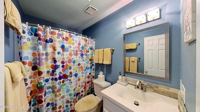 bathroom with walk in shower, vanity, and toilet