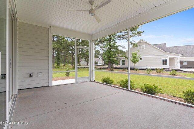 unfurnished sunroom featuring ceiling fan