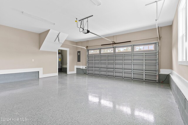 garage featuring electric panel, electric water heater, and a garage door opener