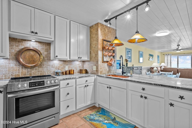 kitchen featuring sink, hanging light fixtures, high end range, white cabinets, and light tile patterned flooring