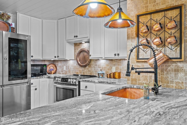 kitchen with white cabinets, light stone countertops, sink, and appliances with stainless steel finishes