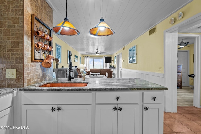 kitchen featuring wooden ceiling, dark stone counters, white cabinets, hanging light fixtures, and ceiling fan