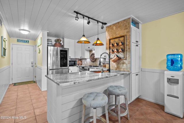 kitchen with white cabinetry, sink, kitchen peninsula, and stainless steel appliances