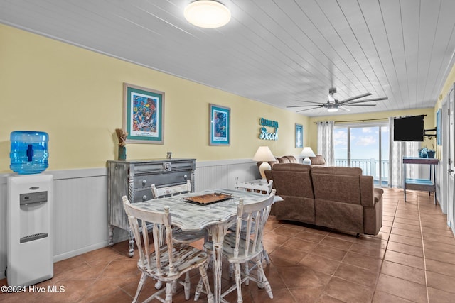 tiled dining space featuring ceiling fan and wooden ceiling