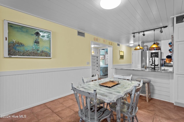 dining room with track lighting and light tile patterned flooring