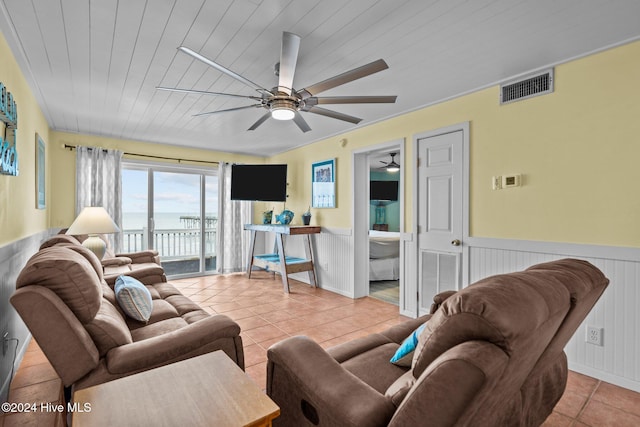 living room featuring wood walls, ceiling fan, light tile patterned flooring, and wooden ceiling