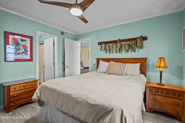 bedroom featuring a textured ceiling, ceiling fan, crown molding, and light hardwood / wood-style flooring