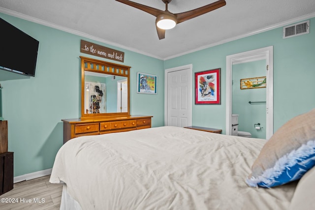 bedroom featuring ceiling fan, light hardwood / wood-style flooring, crown molding, and ensuite bath