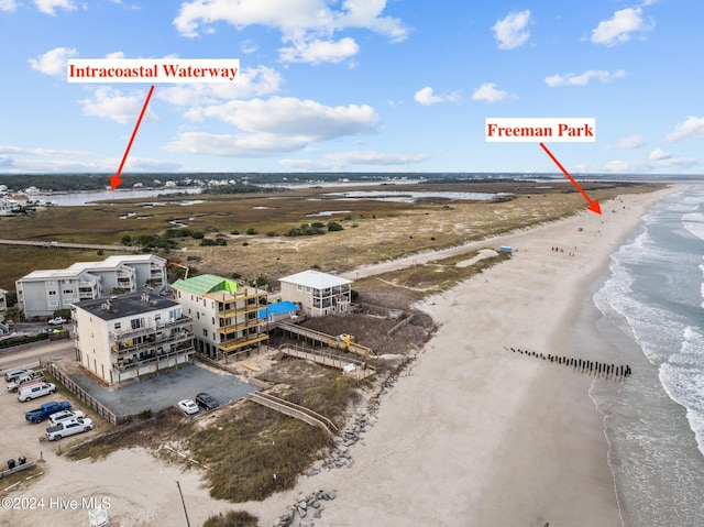 bird's eye view featuring a water view and a beach view