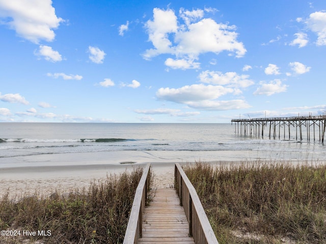 surrounding community with a water view and a view of the beach