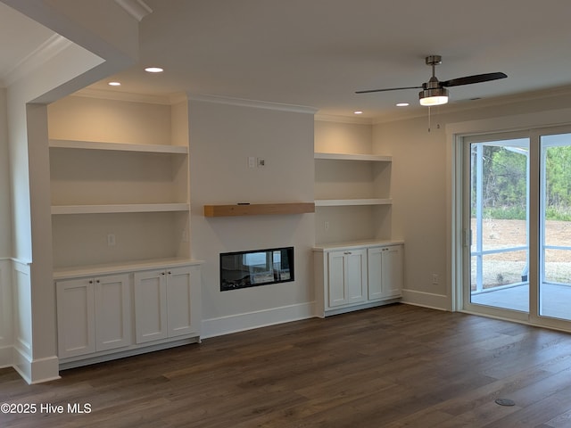 unfurnished living room with dark wood-style floors, built in features, recessed lighting, ornamental molding, and baseboards