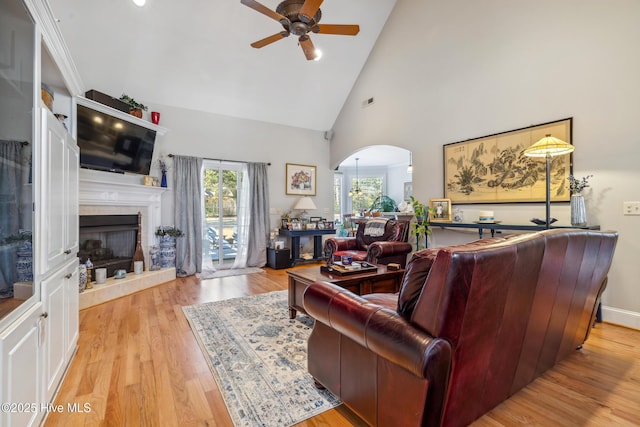 living room featuring ceiling fan, light hardwood / wood-style flooring, and high vaulted ceiling