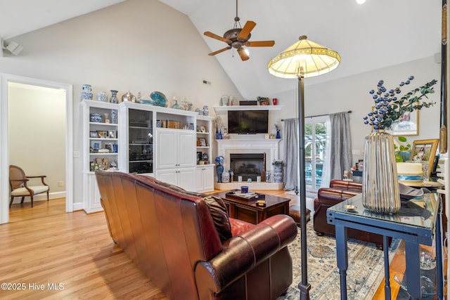 living room featuring ceiling fan, light hardwood / wood-style flooring, and high vaulted ceiling