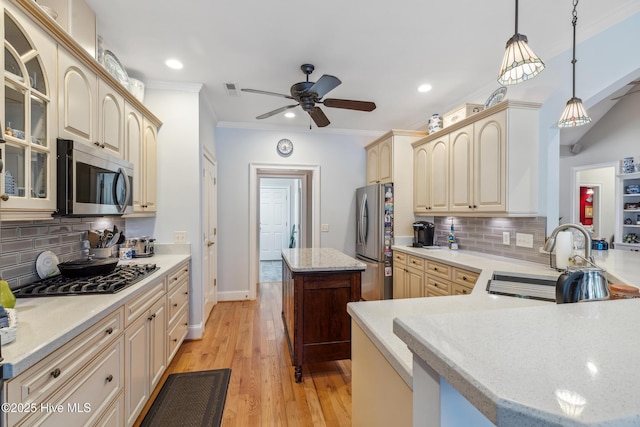 kitchen featuring tasteful backsplash, a center island, sink, hanging light fixtures, and stainless steel appliances