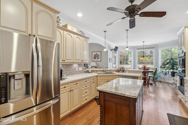 kitchen featuring appliances with stainless steel finishes, pendant lighting, cream cabinetry, and sink