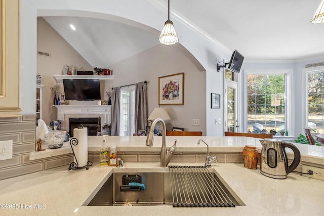 kitchen featuring sink, hanging light fixtures, ornamental molding, and lofted ceiling